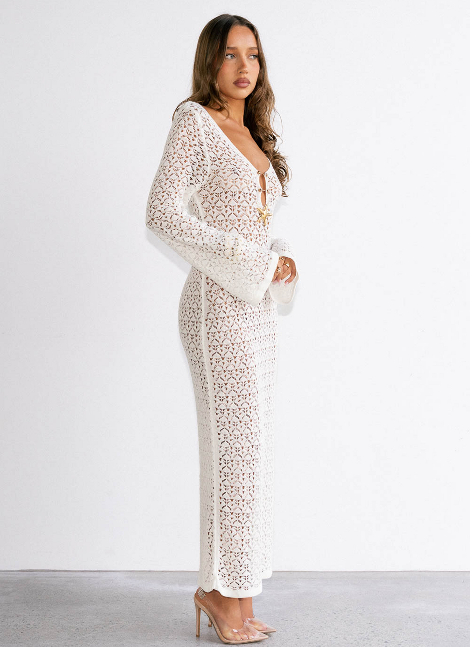 Woman wearing a white lace dress against a white background