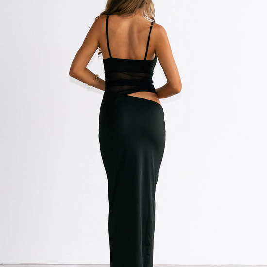 Woman wearing a black dress with cut-out design on a white background