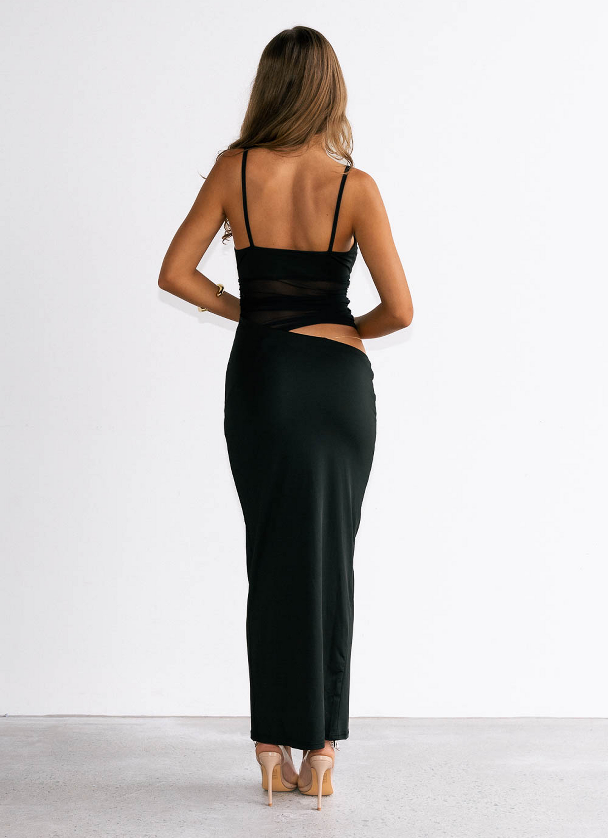 Woman wearing a black dress with cut-out design on a white background