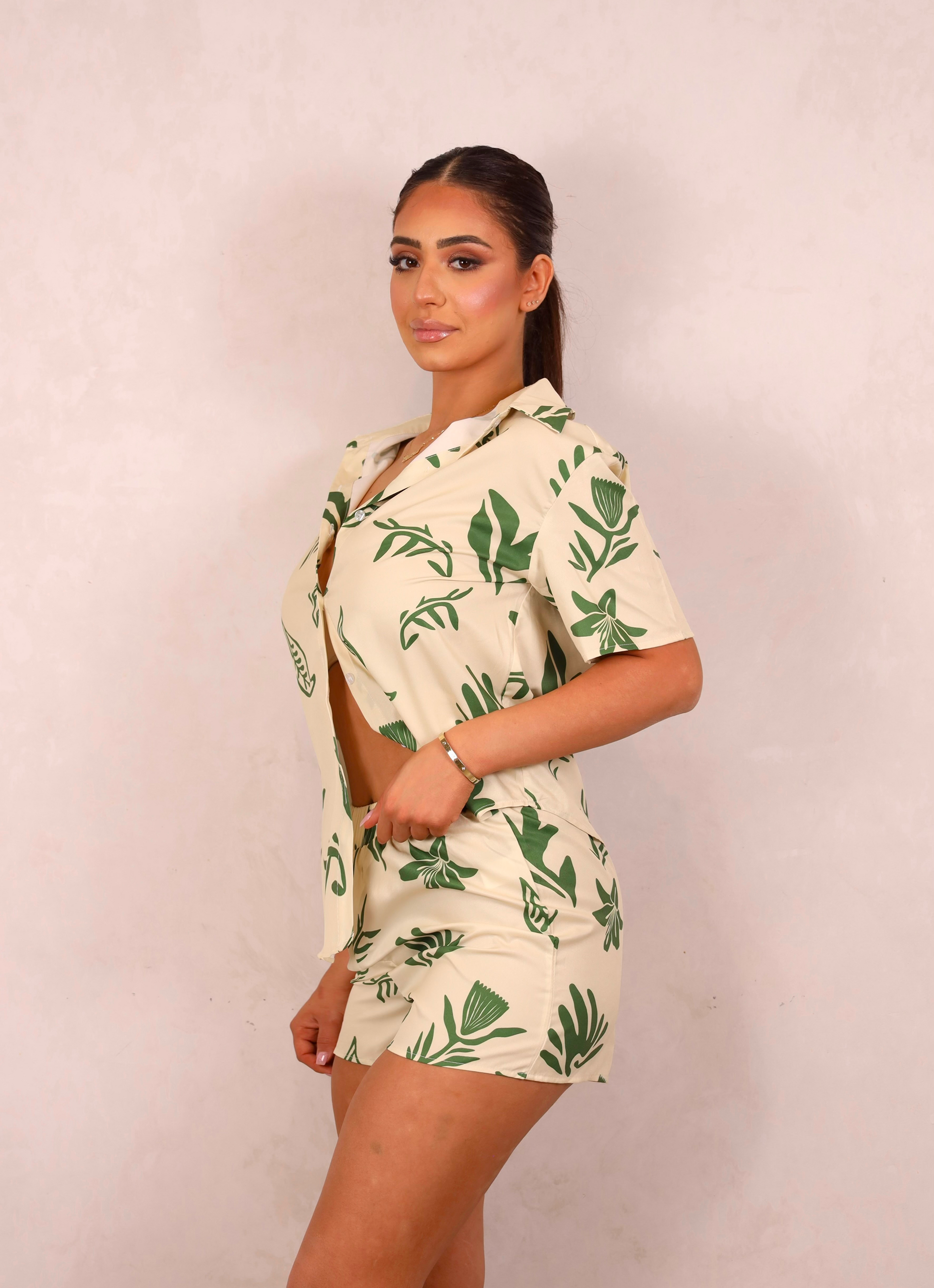 Woman wearing a tropical print outfit against a plain background