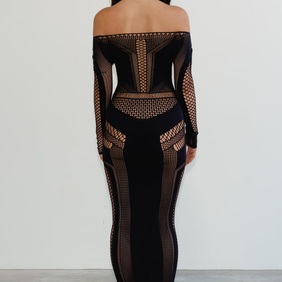 Black off-shoulder dress with mesh details worn by a person on a plain background