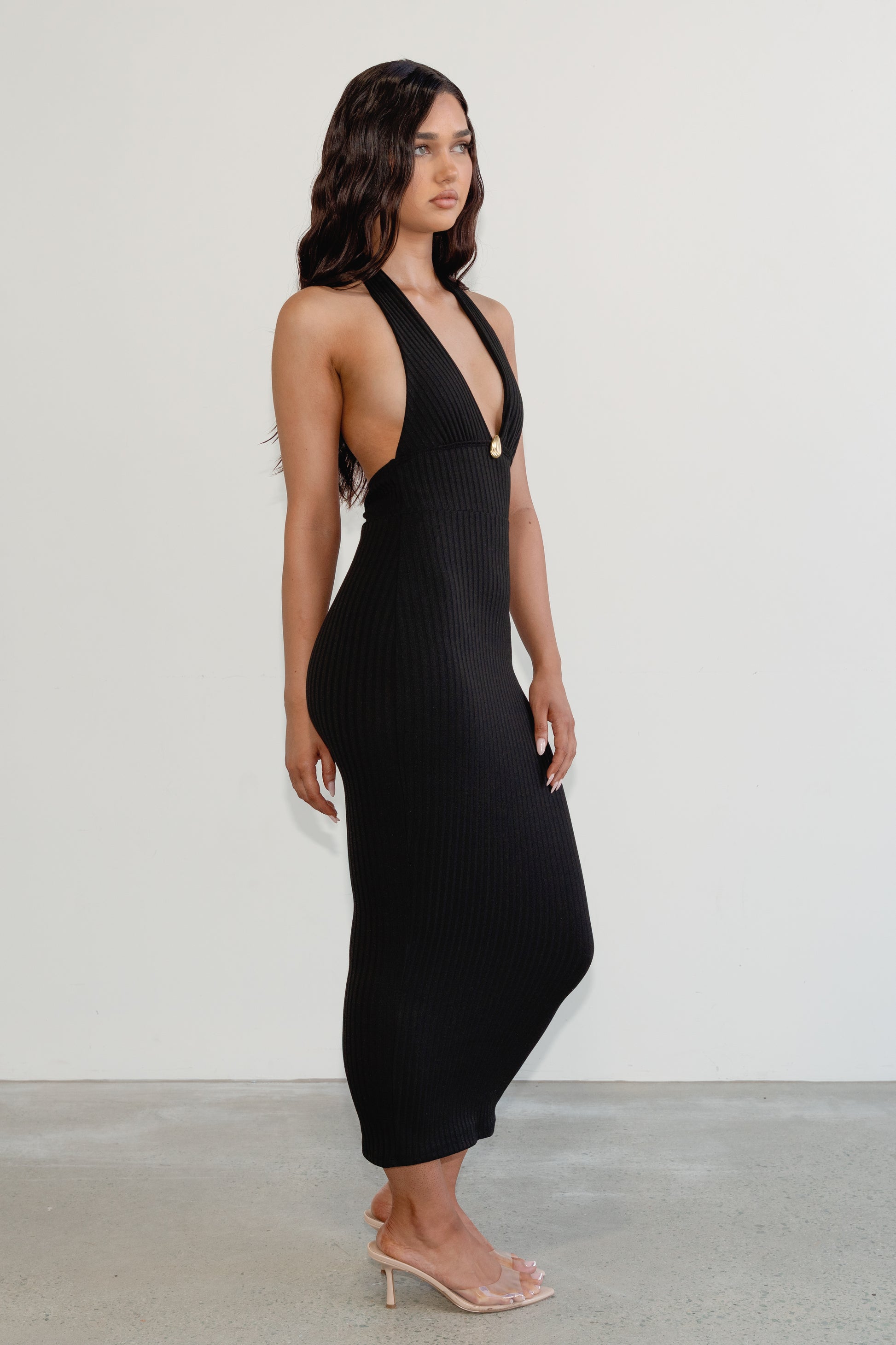 Woman wearing a black dress with a plunging neckline against a white background