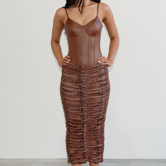 Woman wearing a brown textured dress against a white background