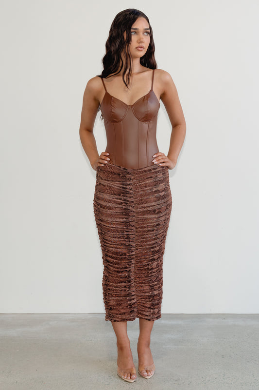 Woman wearing a brown textured dress against a white background