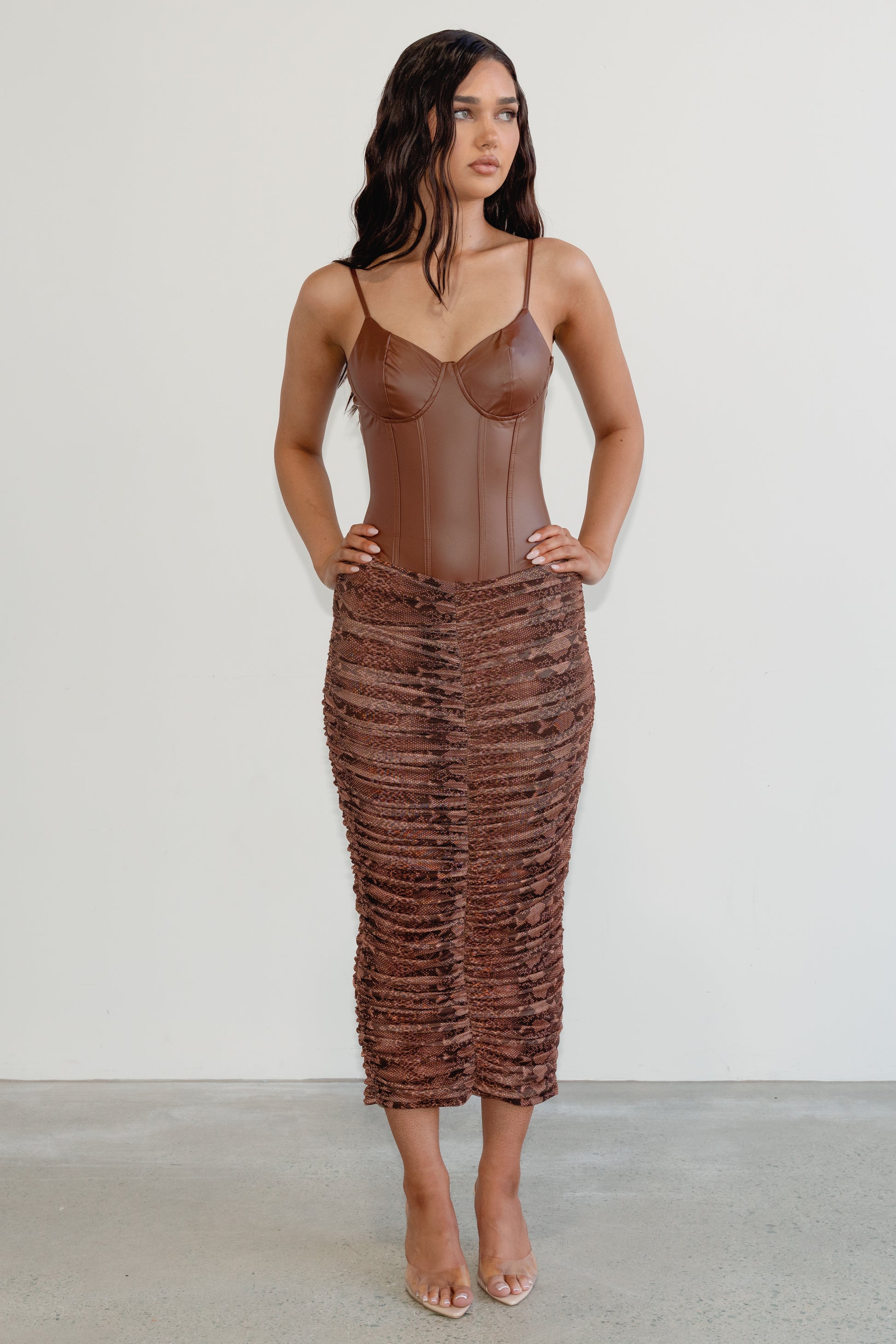 Woman wearing a brown textured dress against a white background