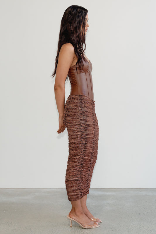 Woman wearing a brown textured dress against a white background