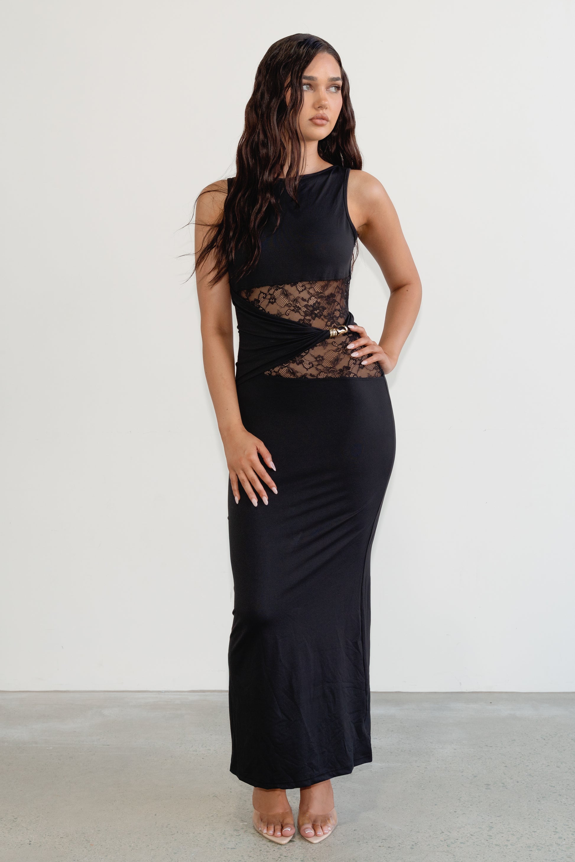 Woman wearing a black sleeveless dress with lace detailing on a white background