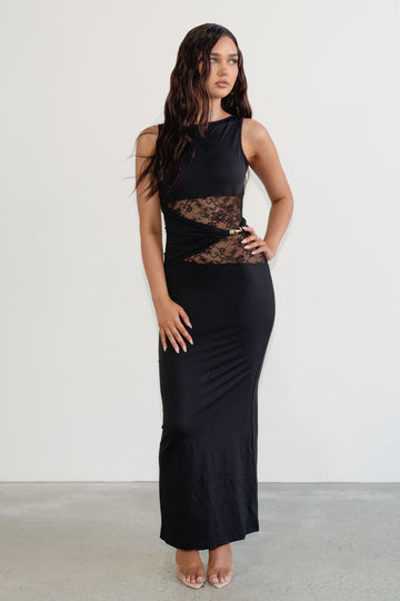 Woman wearing a black sleeveless dress with lace detailing on a white background