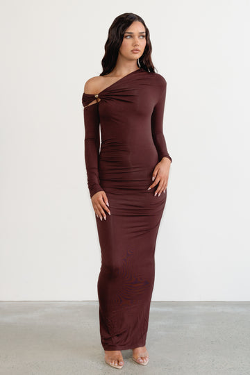 Woman wearing a burgundy off-shoulder dress against a white background