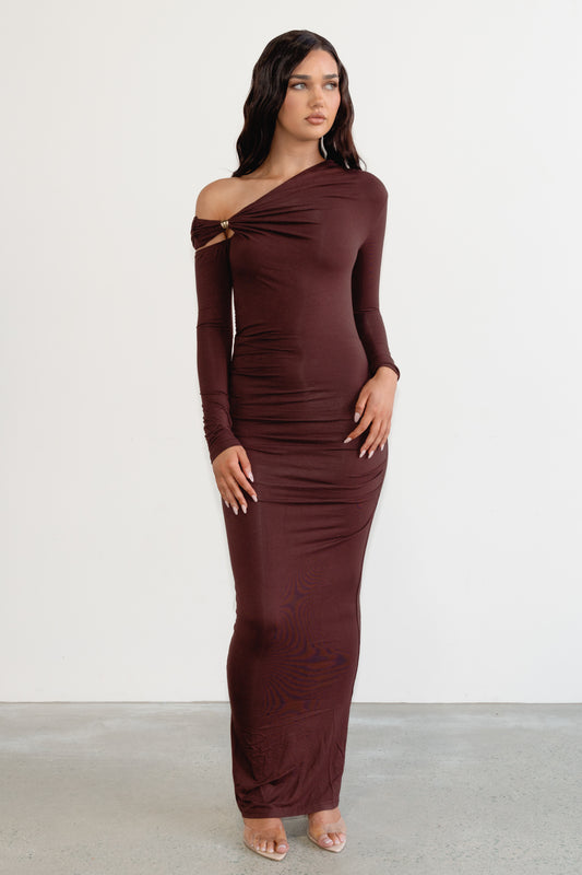 Woman wearing a burgundy off-shoulder dress against a white background