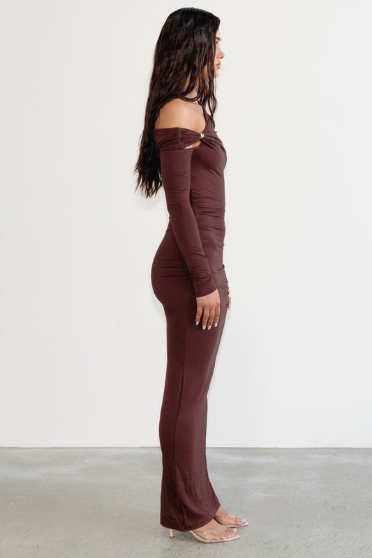 Woman wearing a brown off-shoulder jumpsuit on a white background