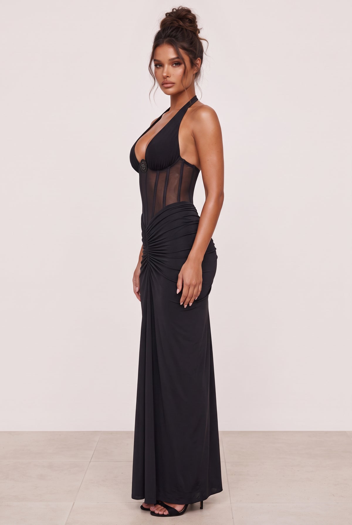 Amaya Sheer Corset Halter Maxi Dress in black, side view showing the sheer bodice, fitted waist and floor-length dress.