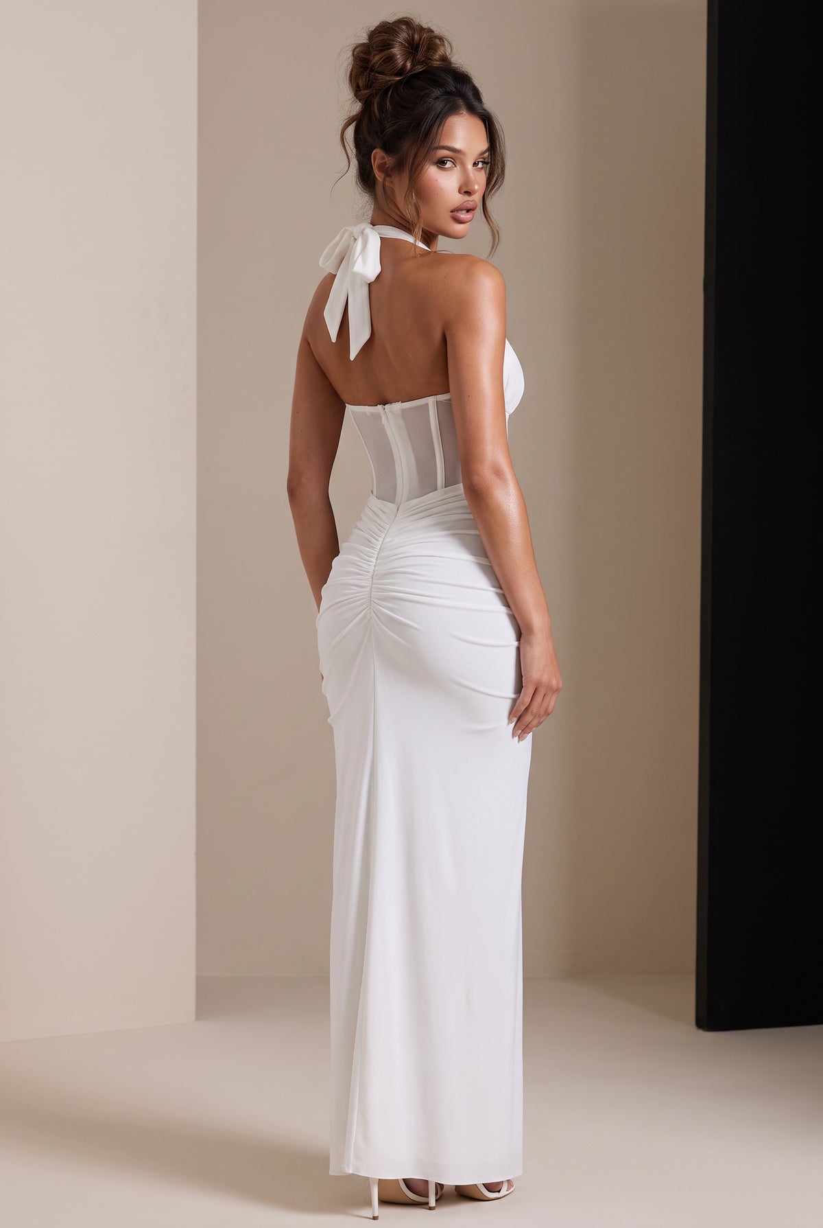 Amaya Sheer Corset Halter Maxi Dress in white, back view showing the halter bow, sheer corset panels and ruched dress.